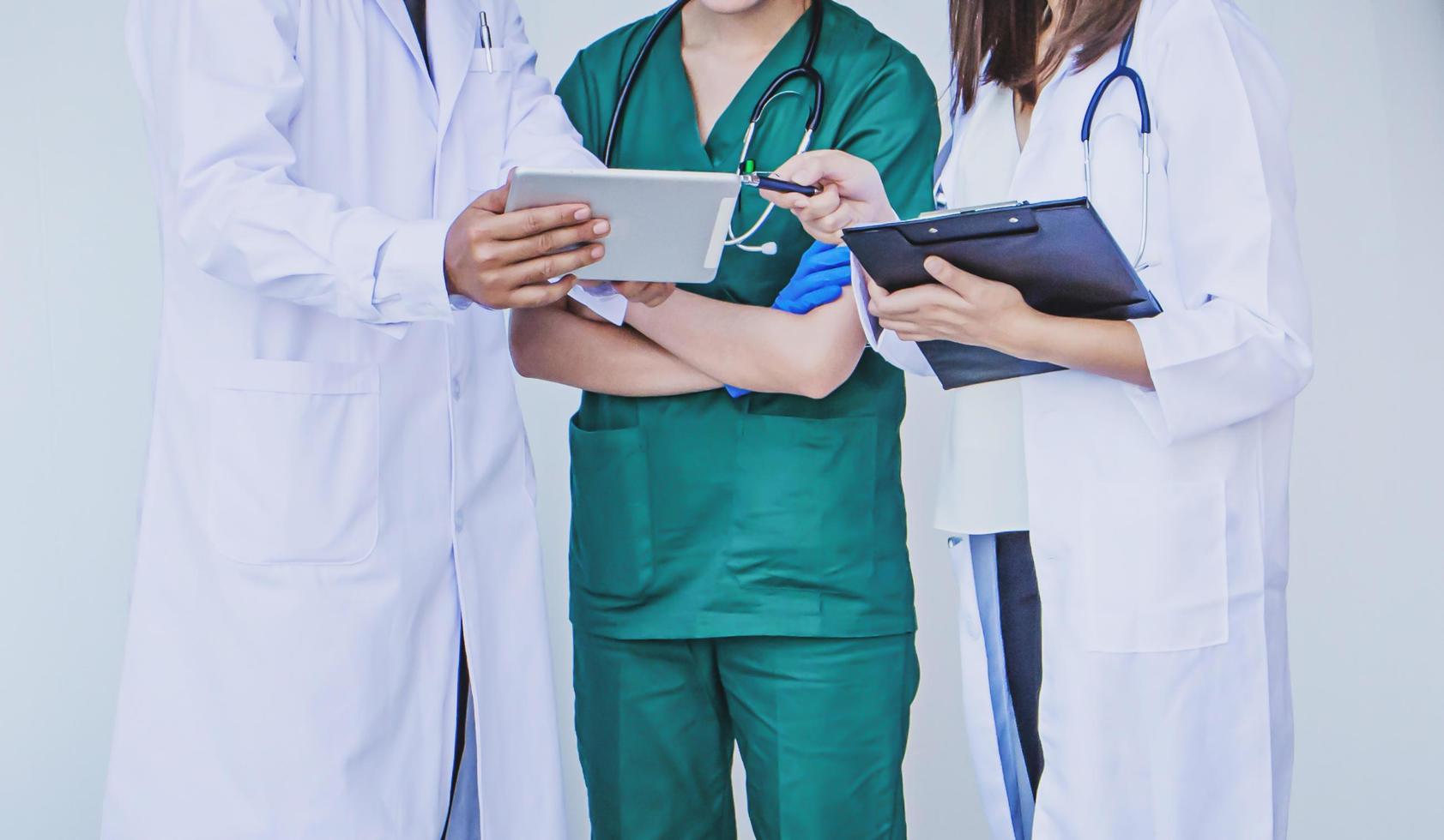 doctor and nurse checking patient information on a tablet device photo