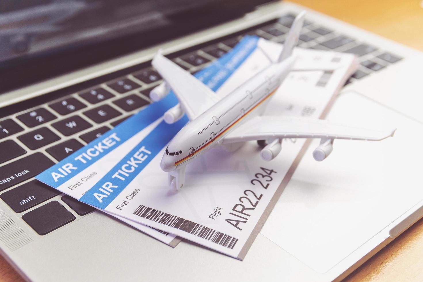 laptop computer and airplane and ticket on table. Online ticket booking concept photo