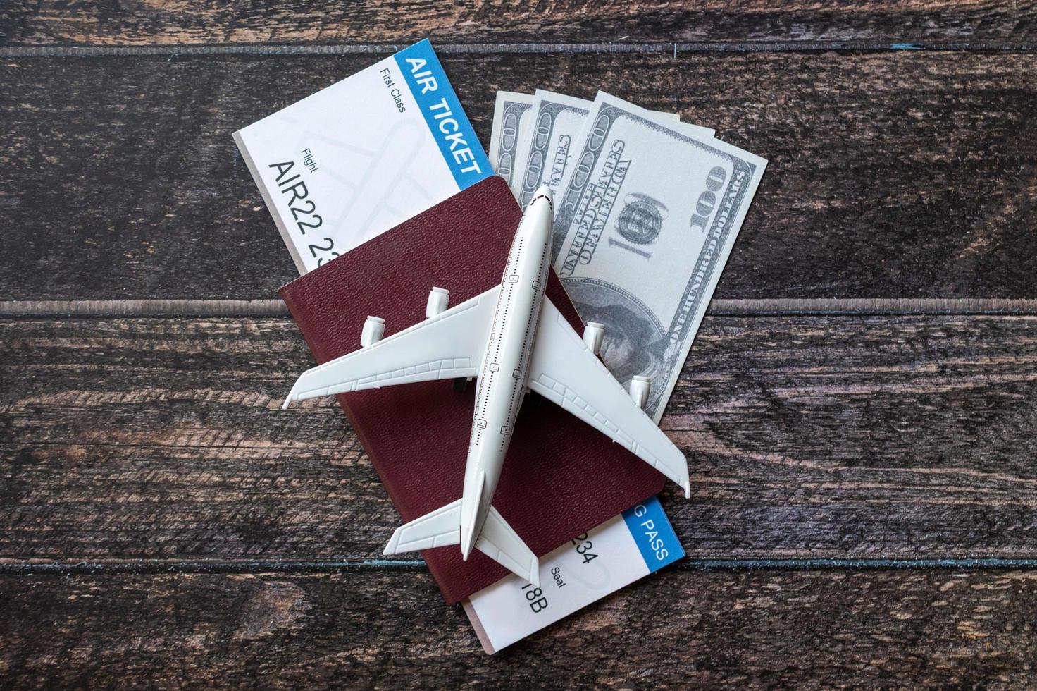 Toy airplane, Air Ticket, credit cards, dollars and passport on wooden table. Travel concept photo