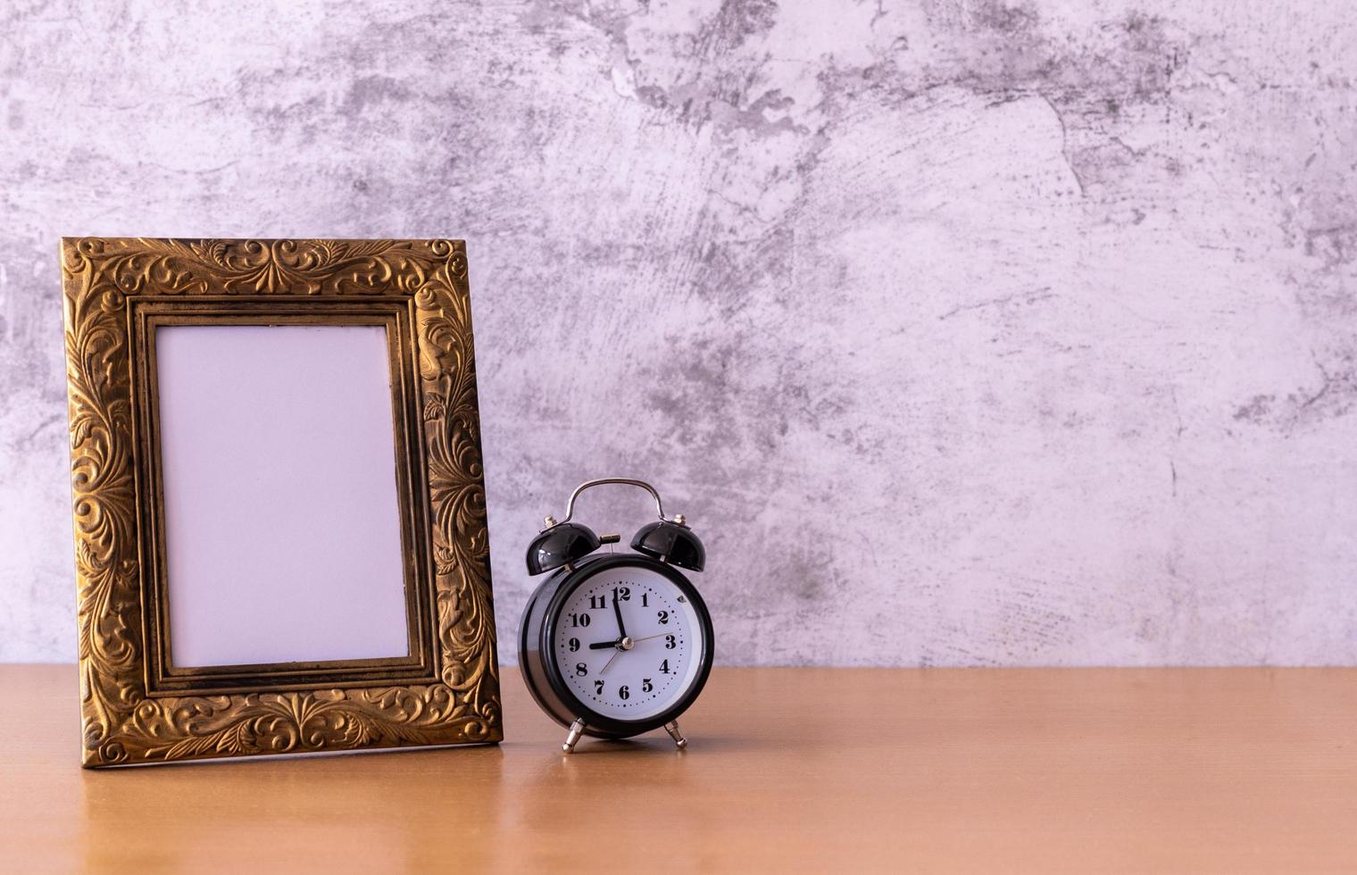 retro style Picture frame and alarm clock on wooden table. Poster product design styled photo