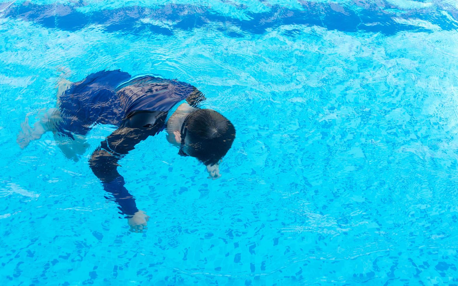 Young boy drowning in the pool photo