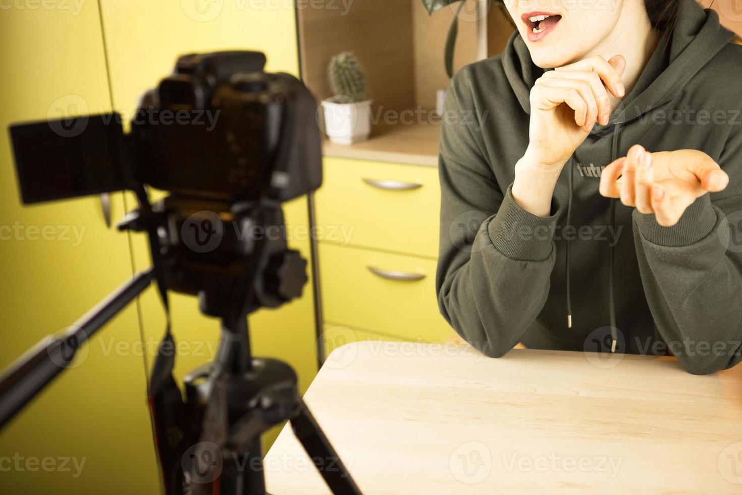 A woman leads a live vlog broadcast, records a video on a camera from home. Remote communication, new reality, blogging, video conferencing photo