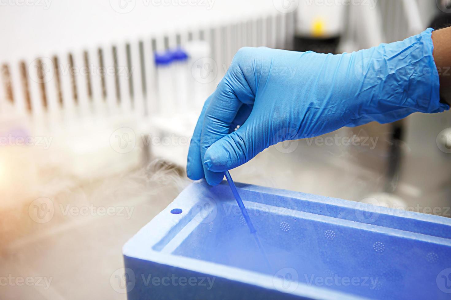 Hands of a scientist in the laboratory with a test tube and a microscope. The invention of the vaccine, a doctor in the clinic of artificial insemination IVF. Tests, fertilization of the egg photo