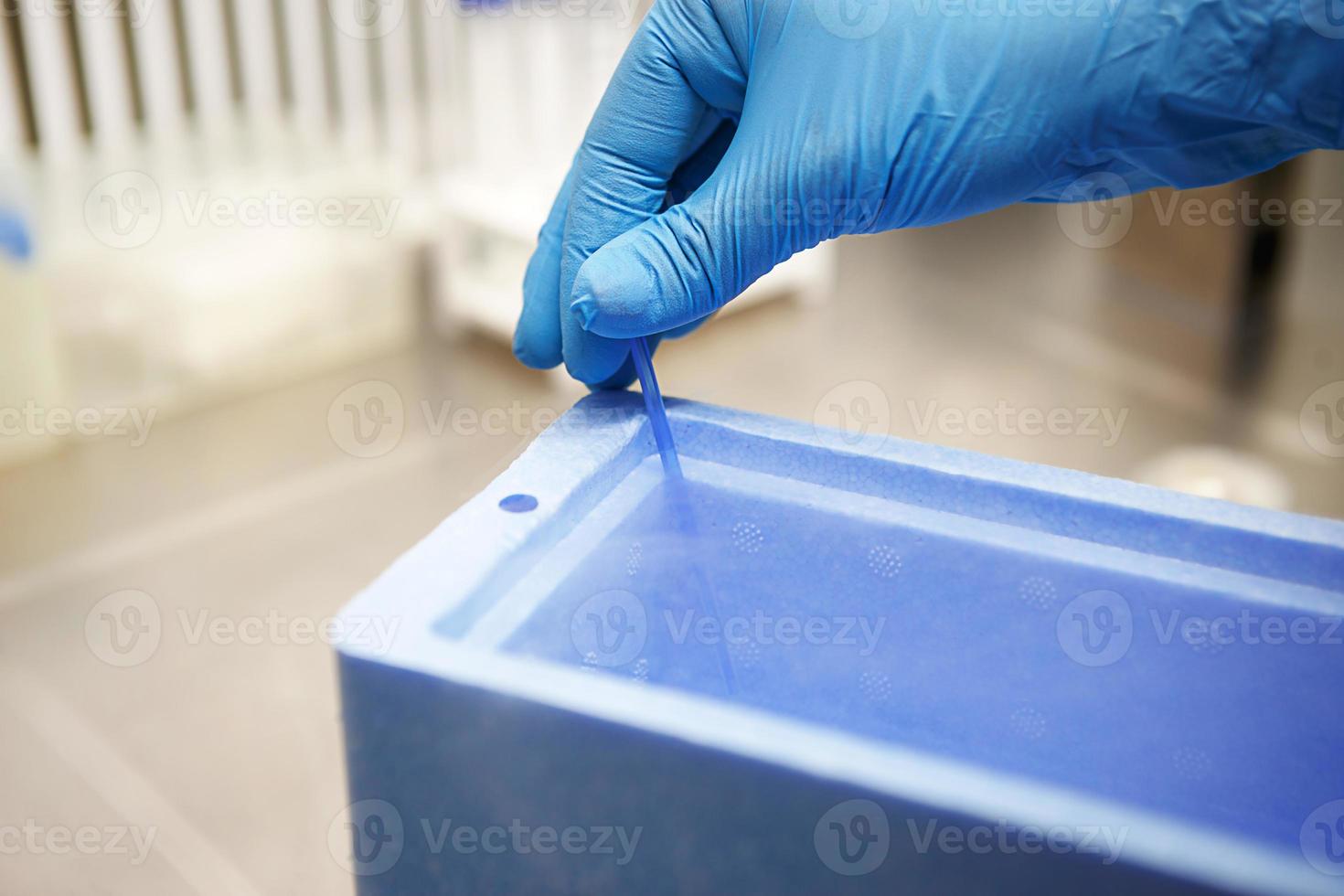 Hands of a scientist in the laboratory with a test tube and a microscope. The invention of the vaccine, a doctor in the clinic of artificial insemination IVF. Tests, fertilization of the egg photo