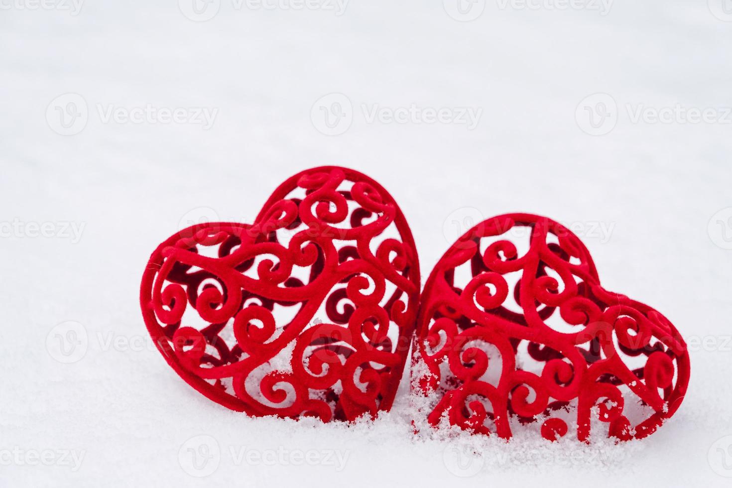 Two red hearts in the snow - a greeting card for Valentine's Day, the holiday of all lovers on February 14. Copy space. Invitation to a date, love, dating photo