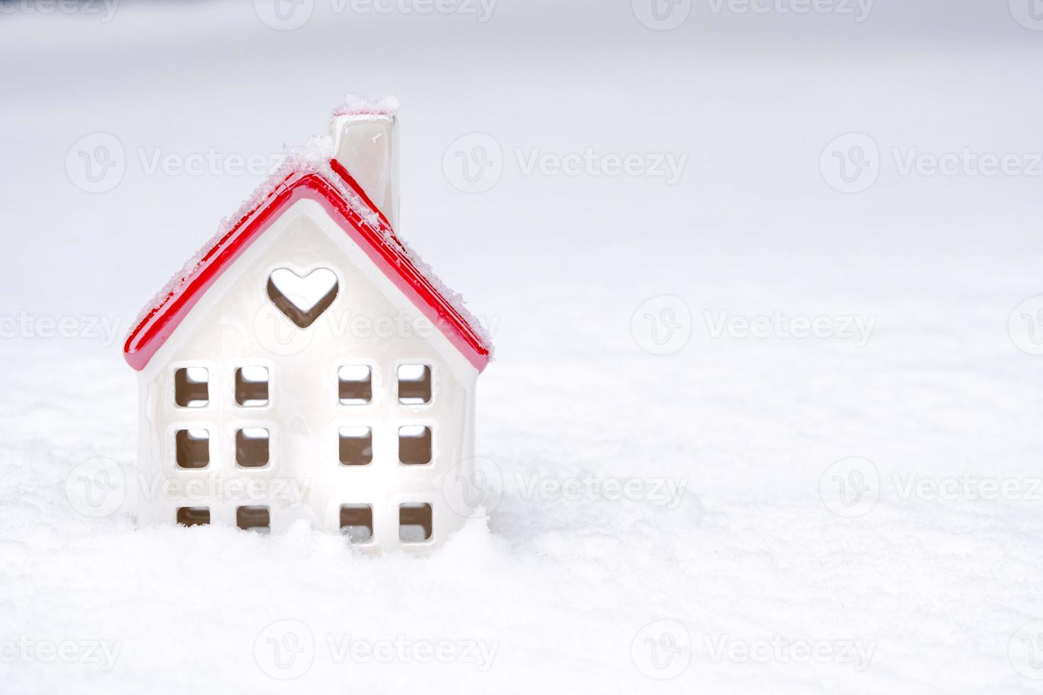The symbol of a house in the snow with a heart is a love nest, housing for a young family, comfort with a loved one. Valentine's day, cozy, cottage, moving, mortgage, warm home photo