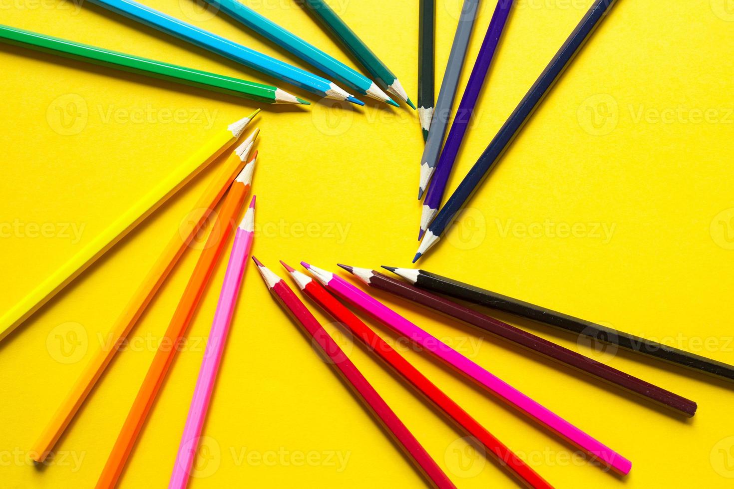 Set of colorful pencils on a yellow background is laid out in a circle in the shape of the square. Copyspace, frame. Back to school, artist, drawing lessons. Stationery for creativity, draw photo