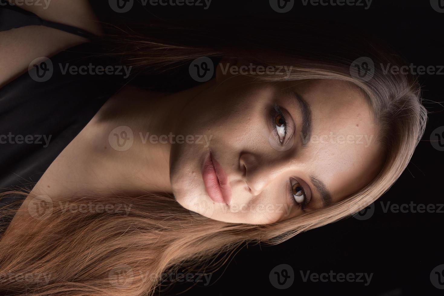 hermosa mujer en vestido negro sobre fondo negro foto