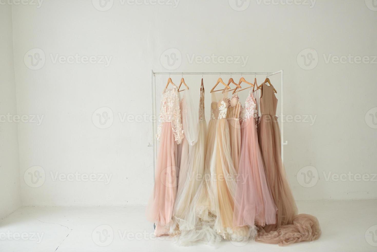 Designer wedding dresses hang on a hanger in a white studio. photo