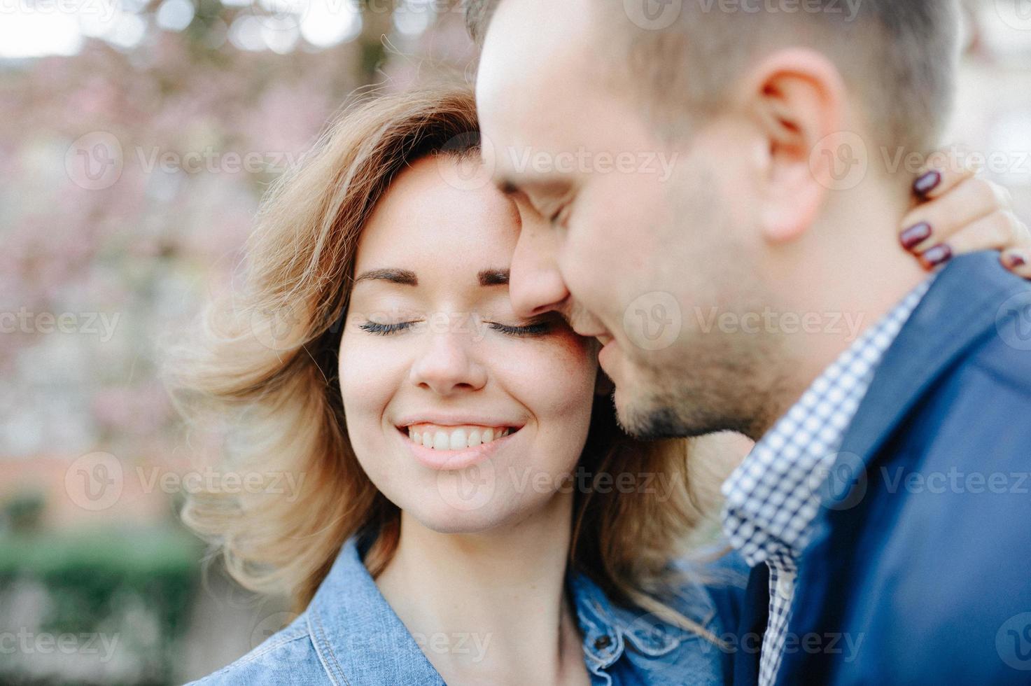 Faces of amorous young couple laughing with closed eyes photo