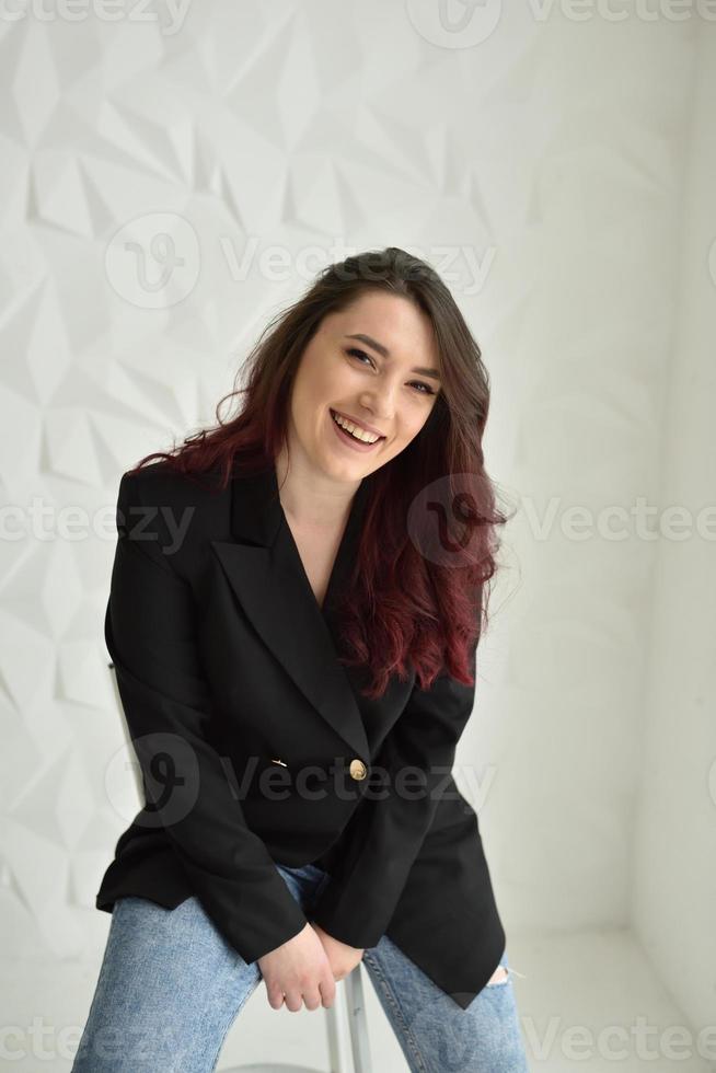 atractiva mujer joven sentada en una silla foto