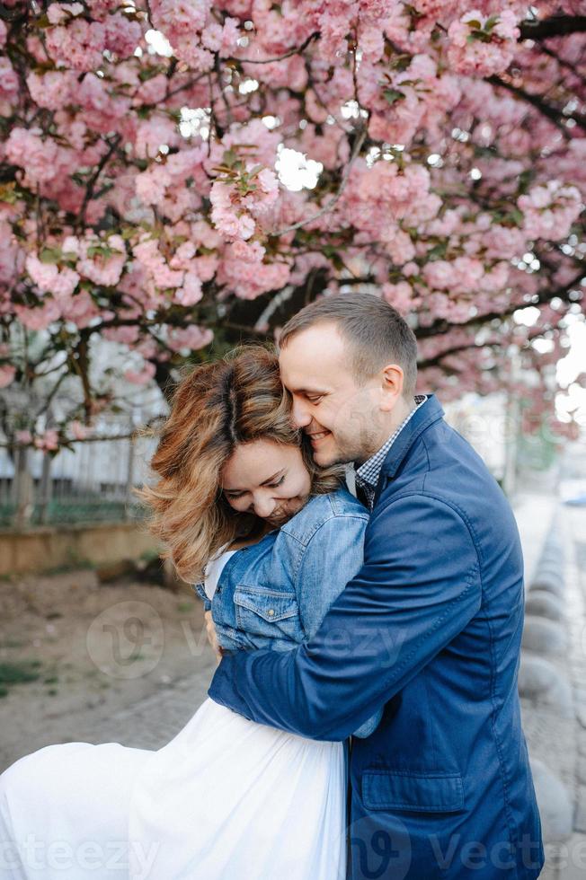 pareja enamorada en un floreciente huerto de manzanas sobre la manta foto