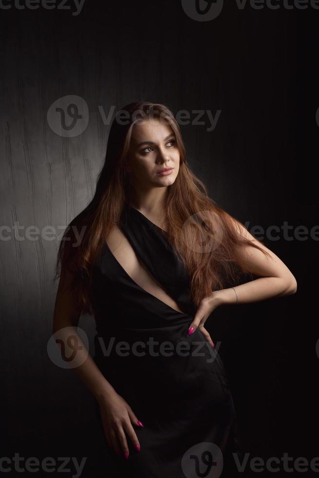 Beautiful Woman in Black Dress on black Backgound photo