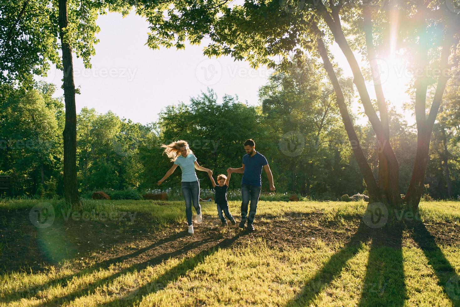 Parents play in the park with their son photo