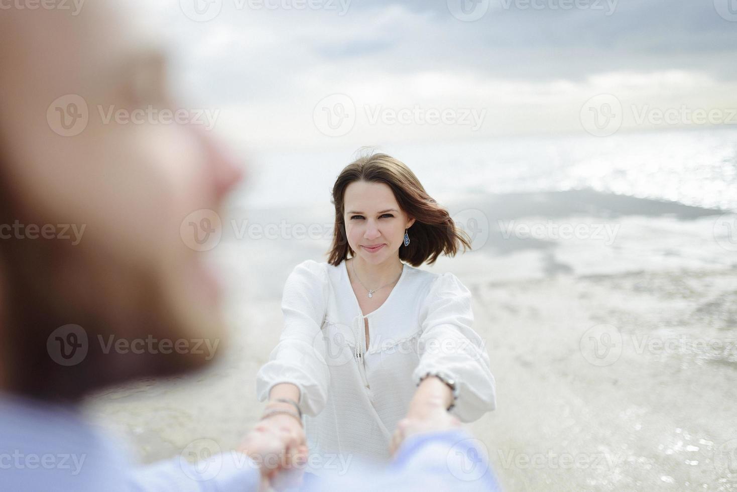 A loving couple, man and woman enjoying summer vacation on a tropical paradise beach with clear sea ocean water and scenic photo