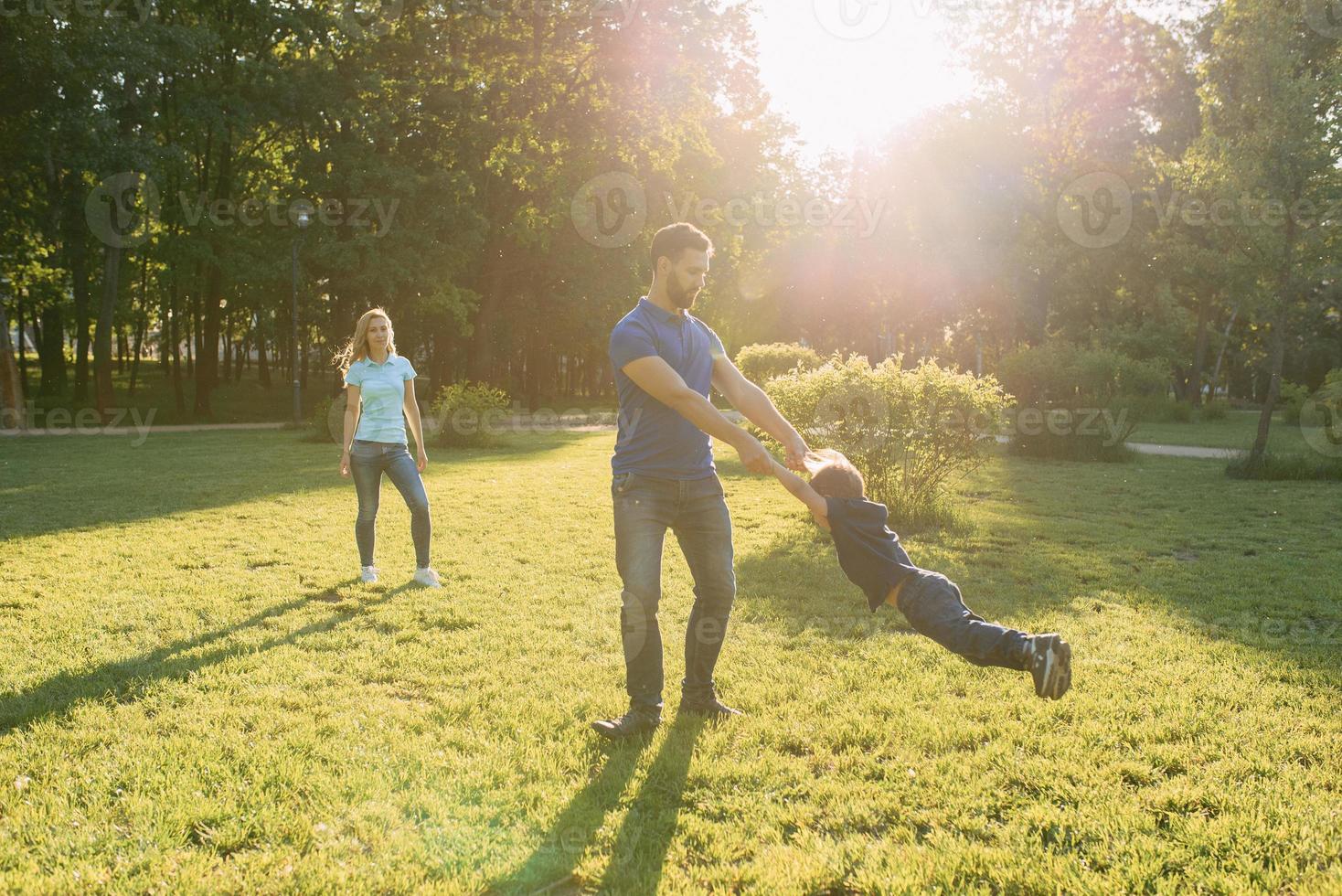 Parents play in the park with their son photo