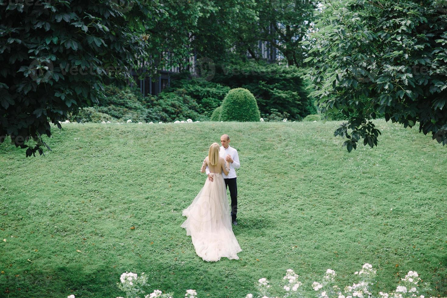 a trendy young couple walks in the city in summer, the young woman wears a luxury dress photo