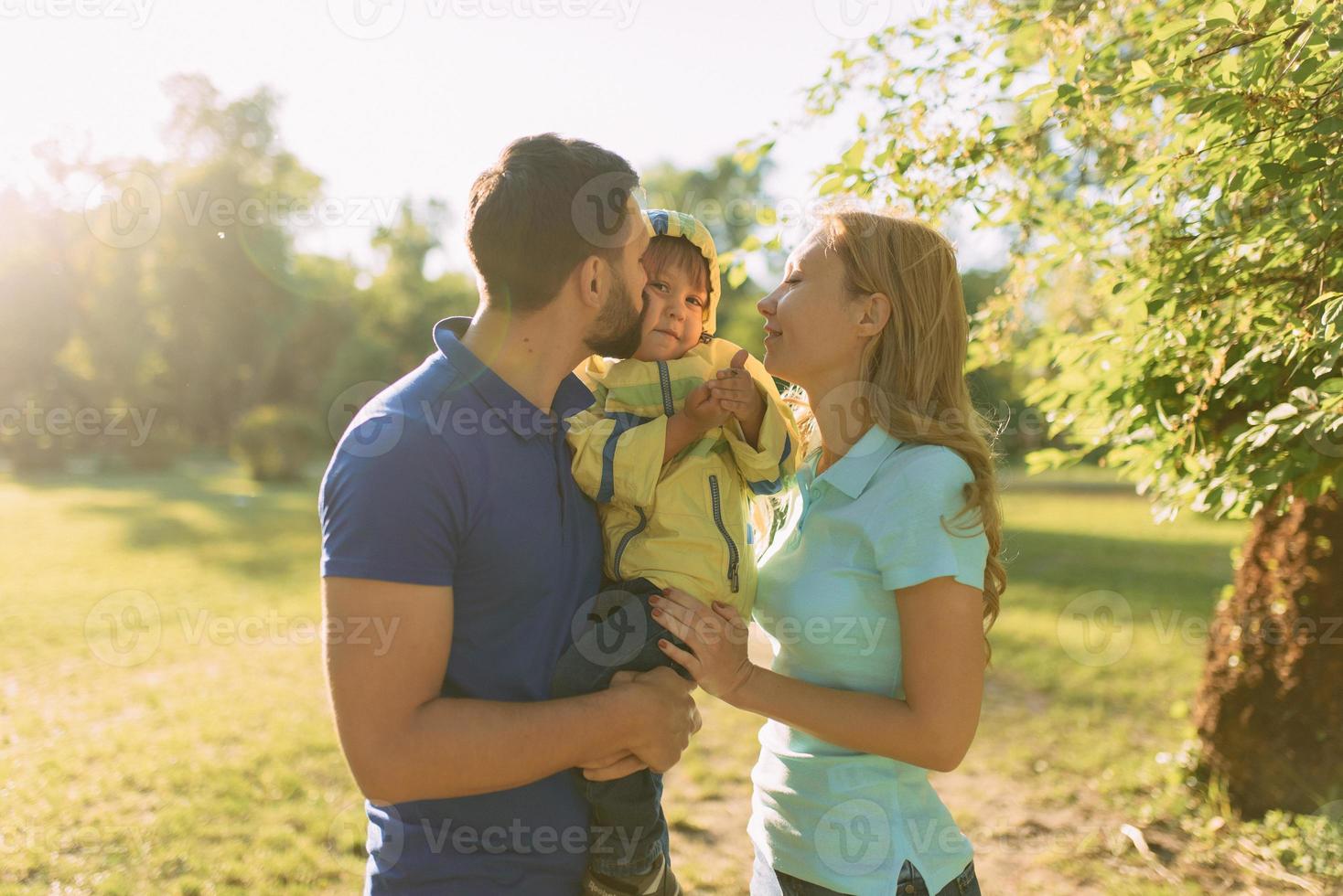 Parents play in the park with their son photo