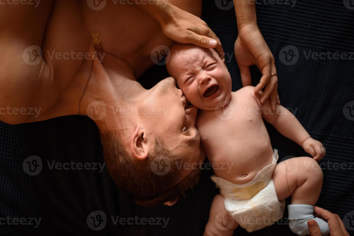 A young father lies next to his little son photo
