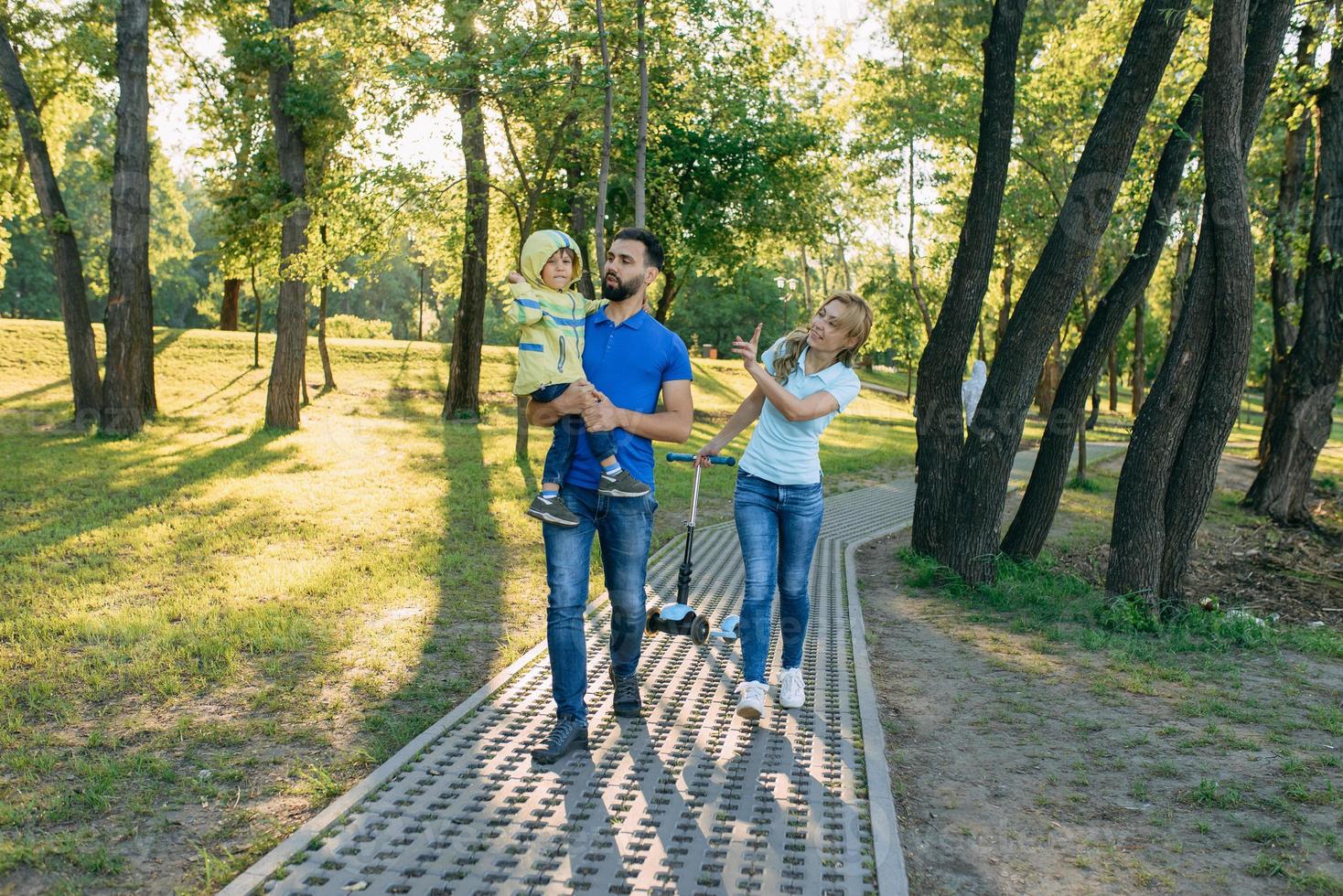 Parents play in the park with their son photo