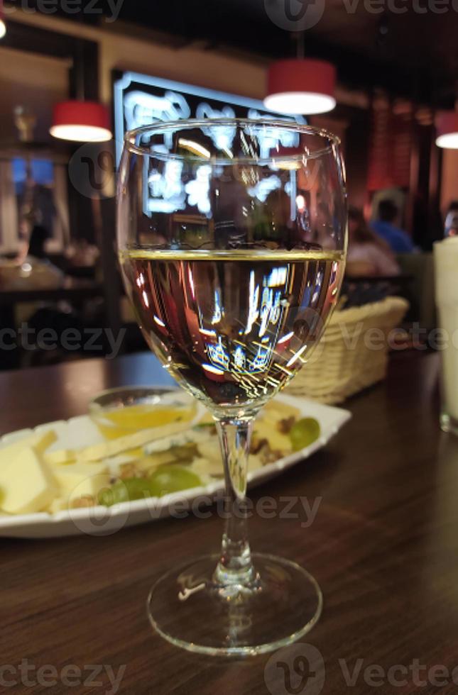 una copa de vino al fondo de un elegante bar foto