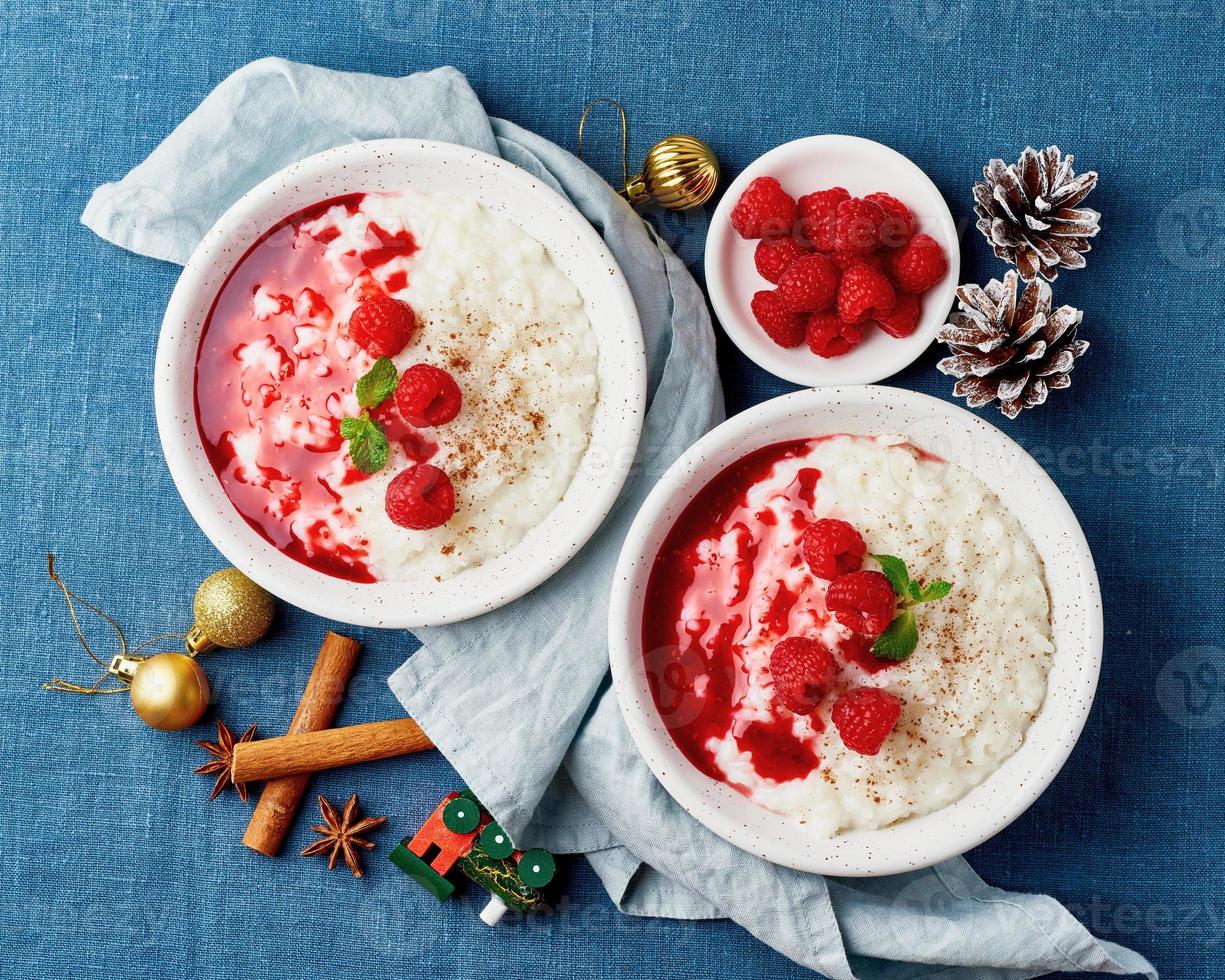 Rice pudding. Christmas food. French milk rice dessert with raspberries. Dark background. photo
