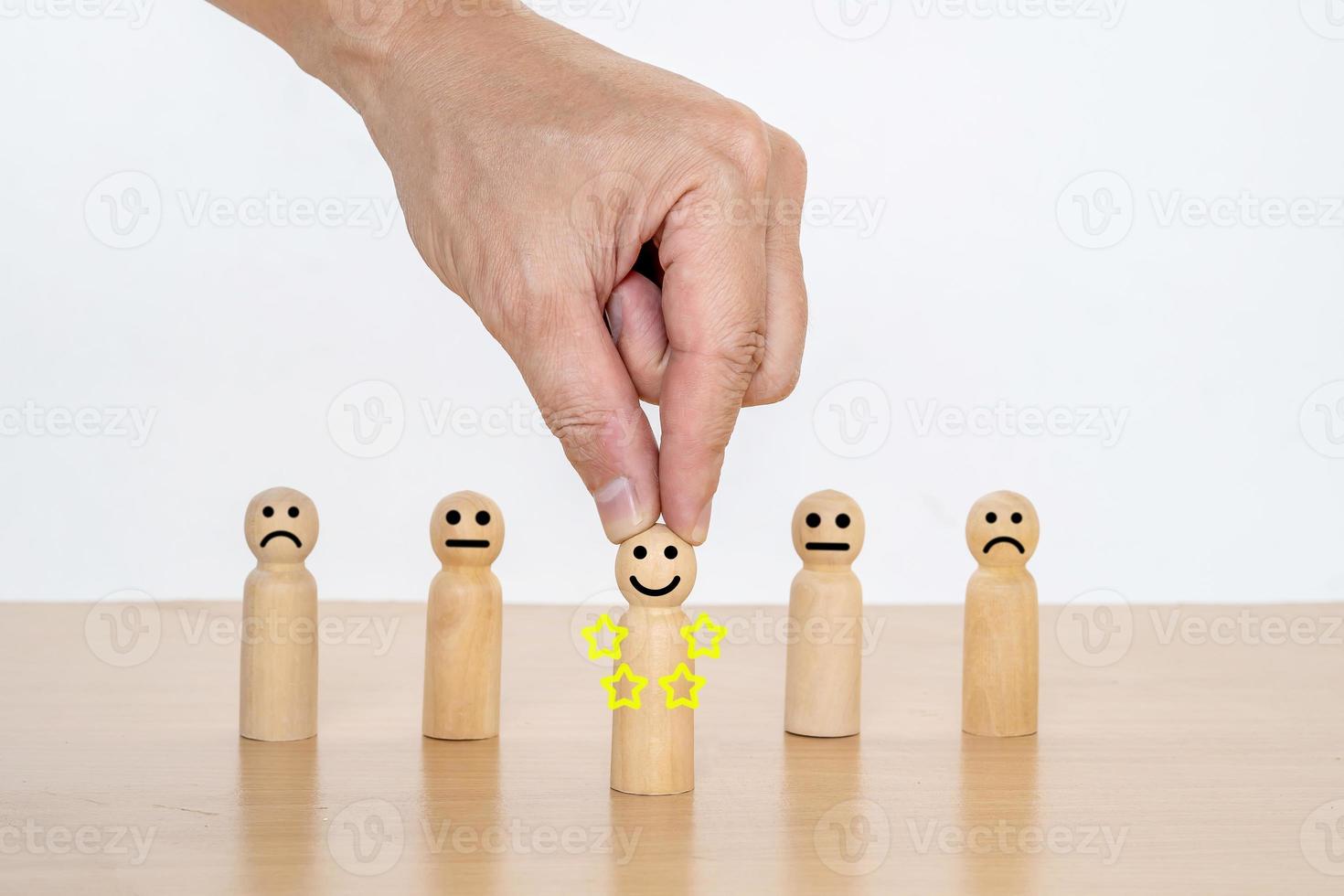 Close-up hand of a businessman choosing smiley face on wood doll, best excellent business services rating customer experience. Satisfaction survey concept, 5 Star Satisfaction. photo