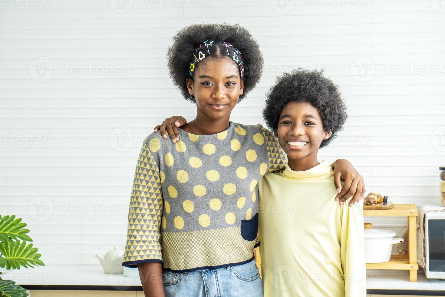 Happy Kids.Two cute adorable siblings african american children hug the neck and smile, Older sister hugs little brother by the neck photo