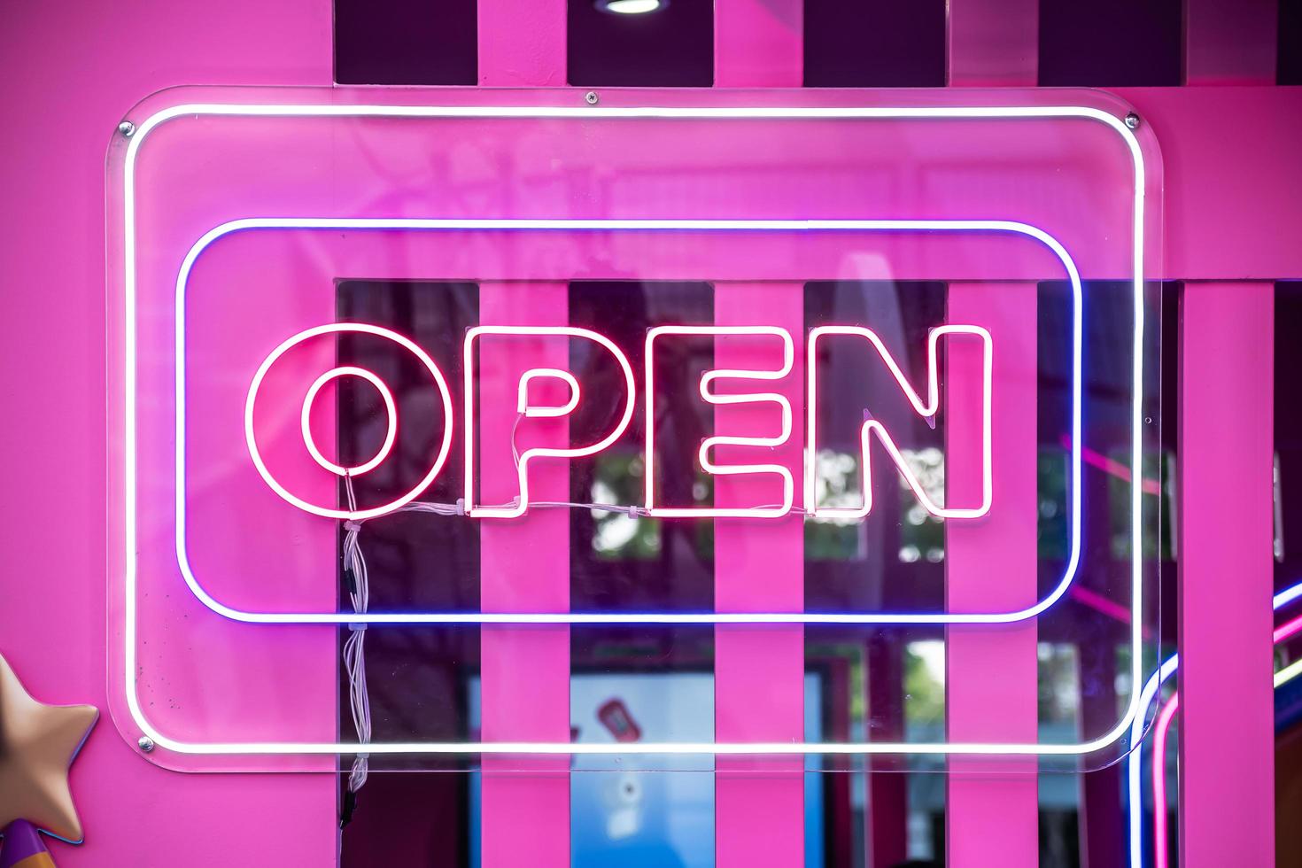 Neon light color blue Open sign on a glass window for business front of shop. photo