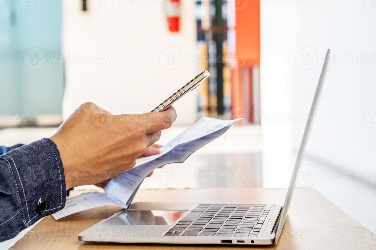 Hands of man using mobile smart phone payment online with family budget cost bills on desk, plan money cost saving, investment, business finance, expenses concept photo