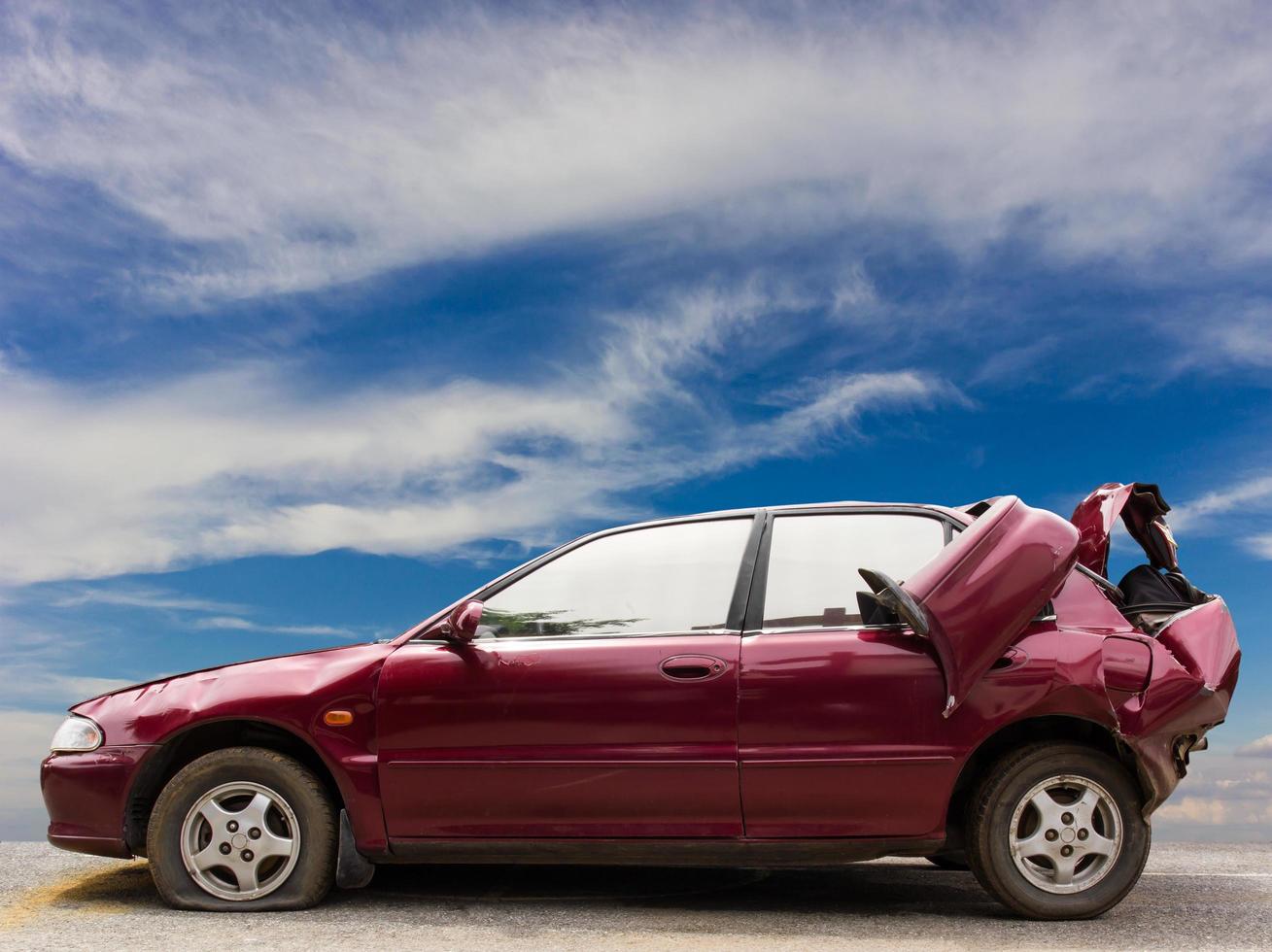 Red car bumpers demolished with sky. photo