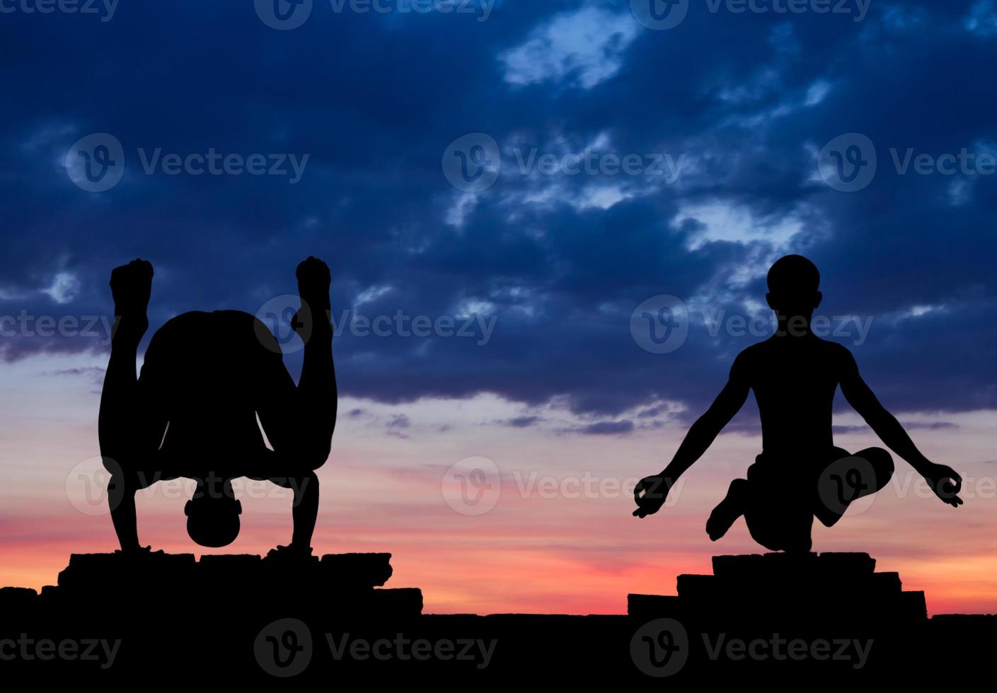 Silhouette in yoga pose on a brick wall. photo