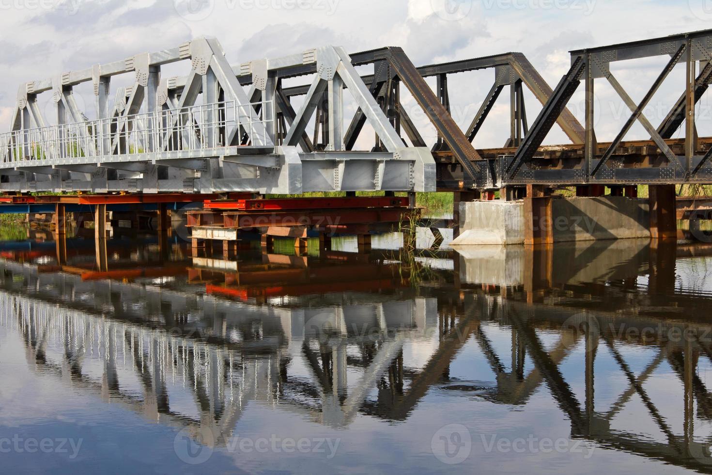 Maintenance of railway steel bridge, water reflection. photo