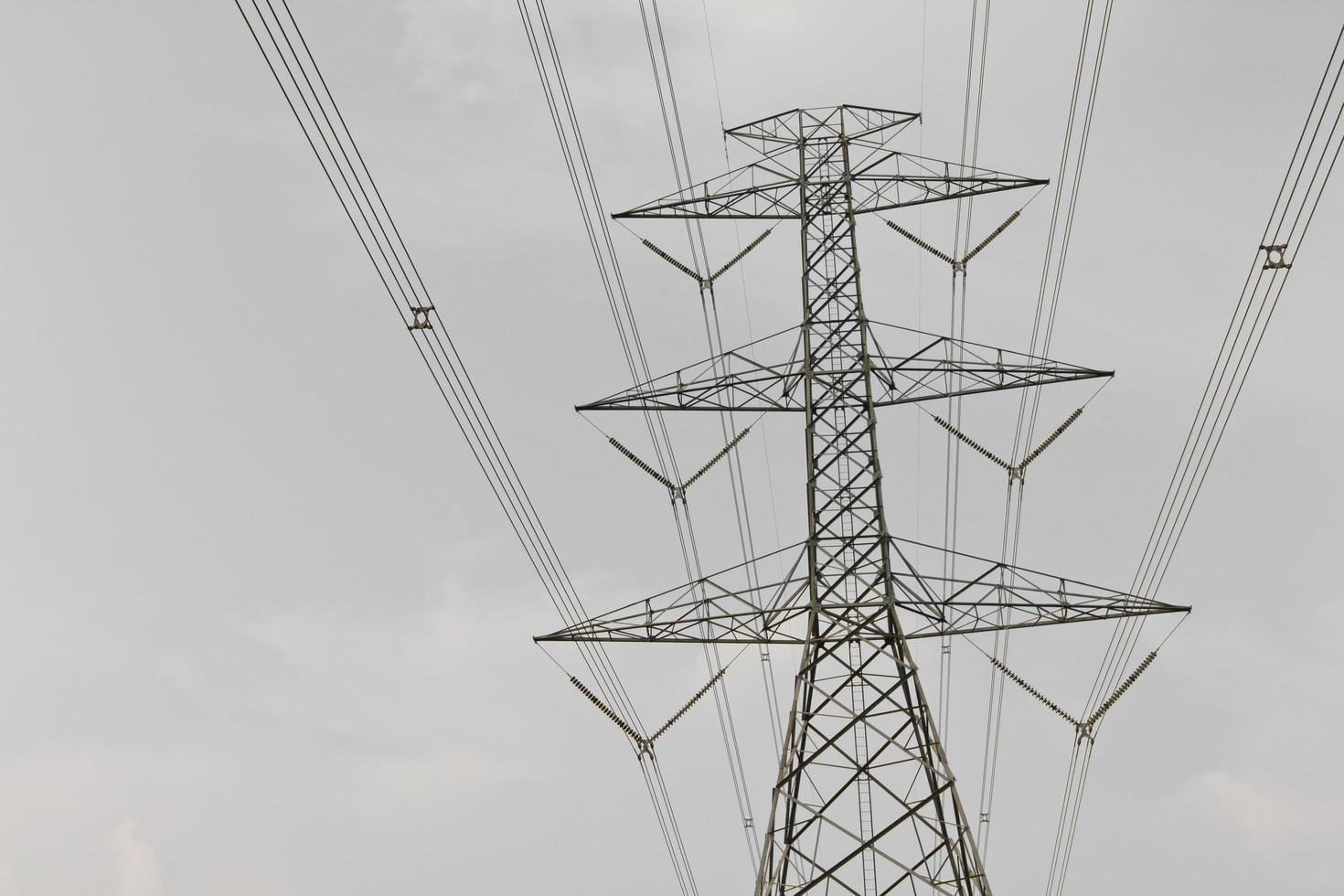 High voltage power pylons against cloudy. photo