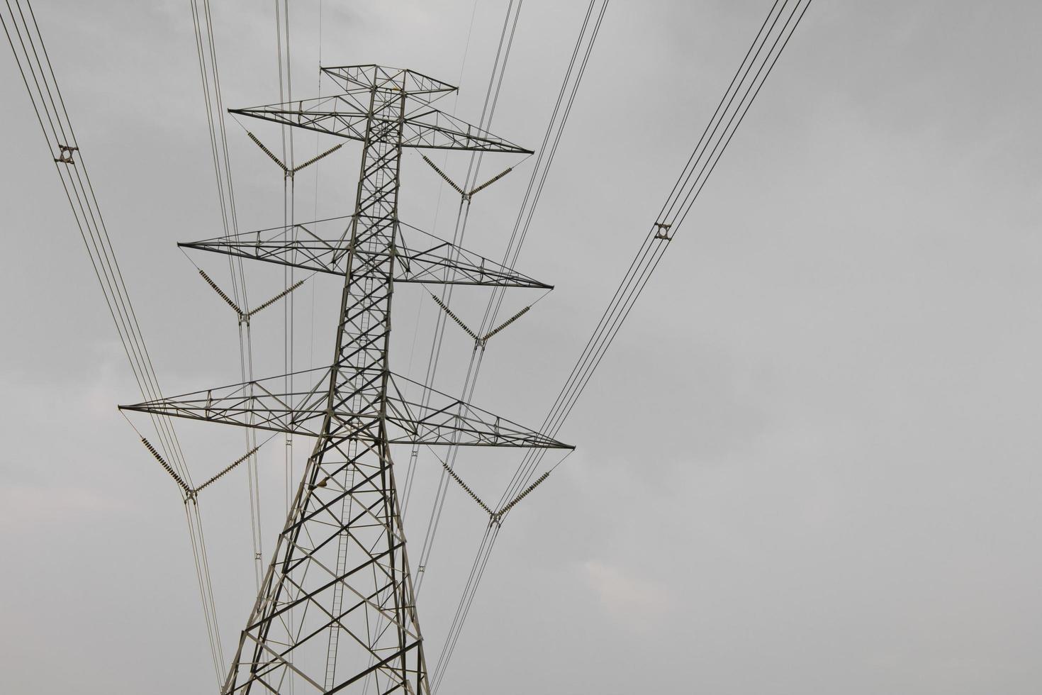 High voltage power pylons against cloudy. photo