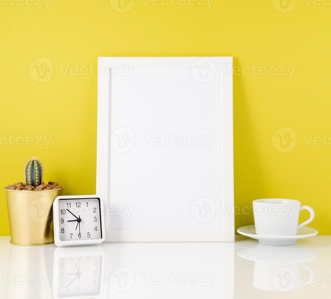 Blank white frame, clock, succulent,mug with tea or coffee again photo