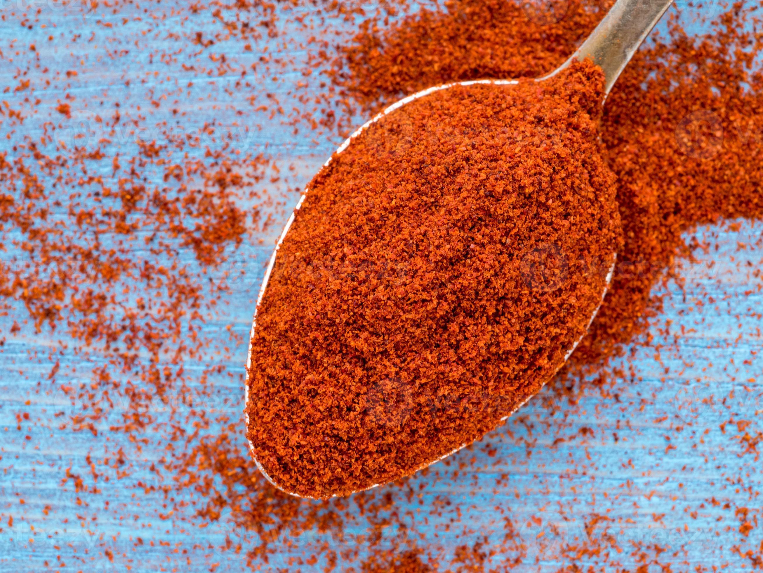 one heaping scoop of spices of paprika, powder scattered on the wooden