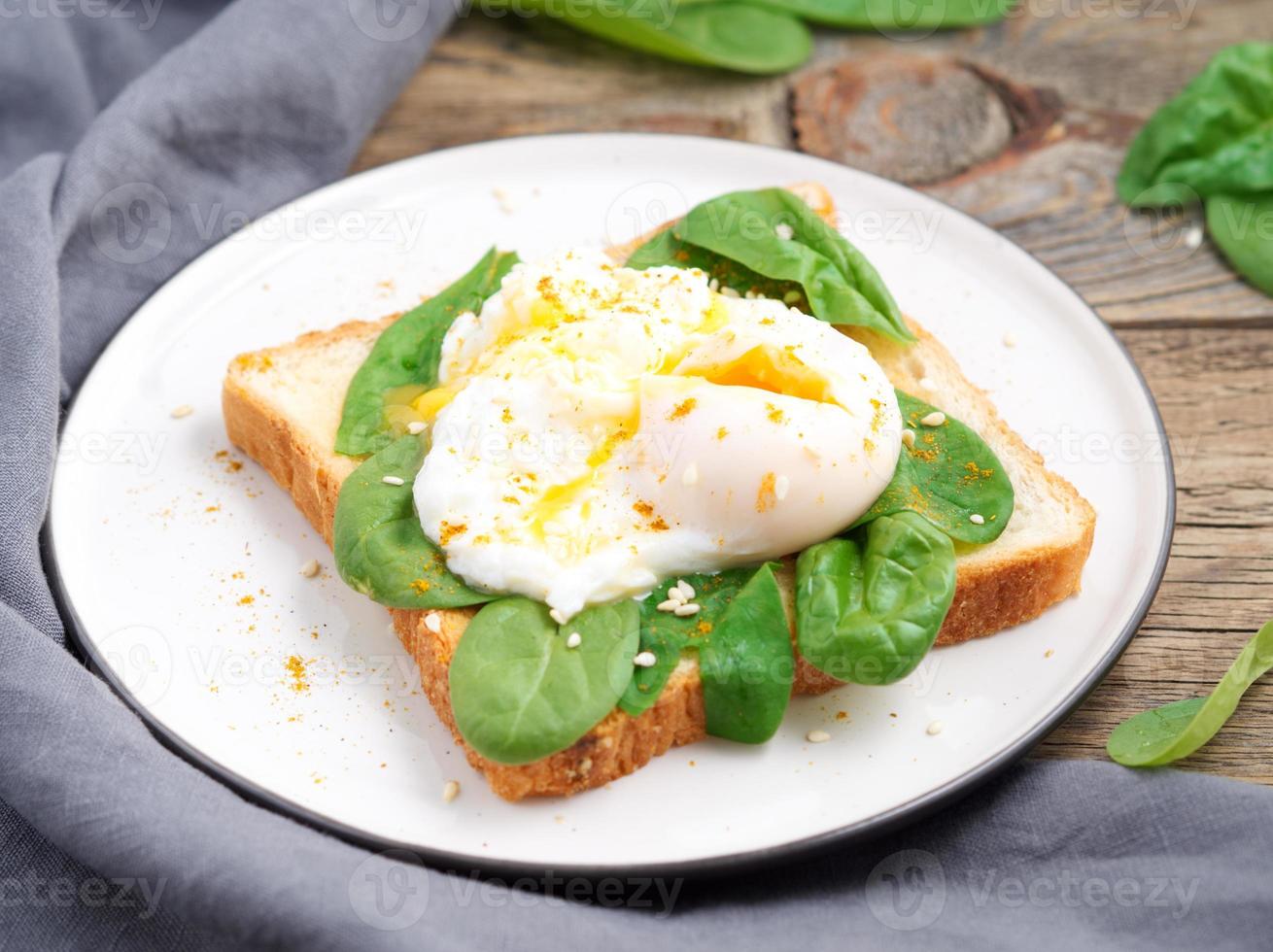 Healthy breakfast with toast and poached egg with green salad, spinach. Side view. photo