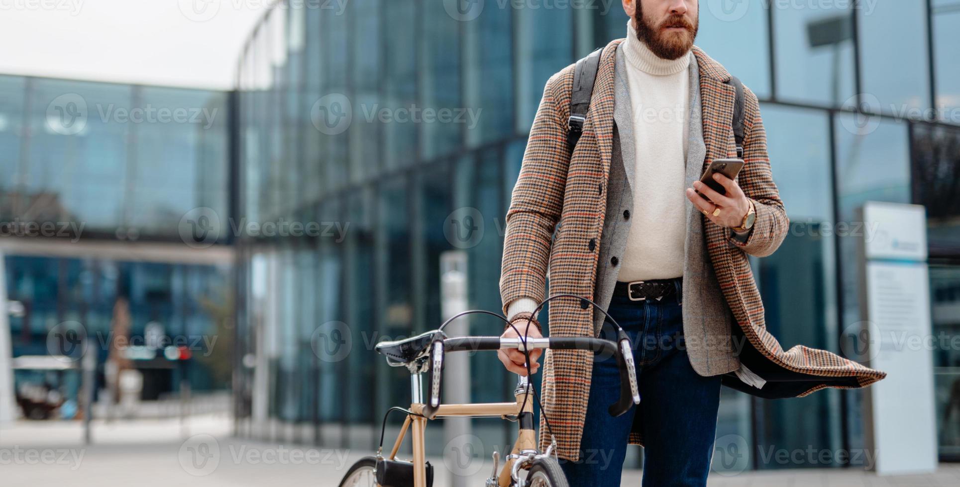 parte media del hombre de negocios hipster usando la navegación de aplicaciones móviles. foto de cubierta. ubicación del centro de negocios. yendo a trabajar