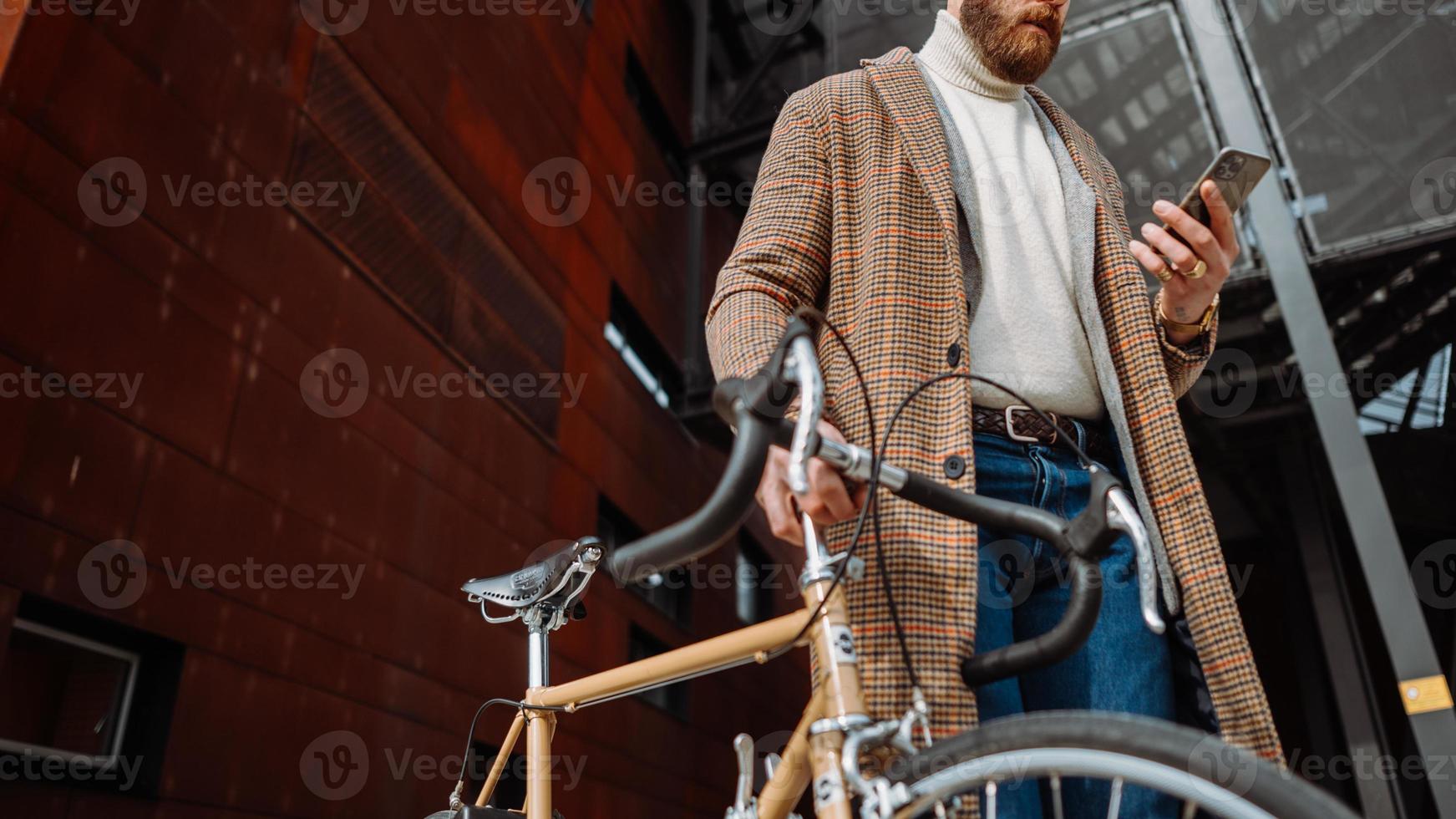 Midsection Detail of hand with phone. Businessman holding mobile phone. On the way to work with bicycle photo