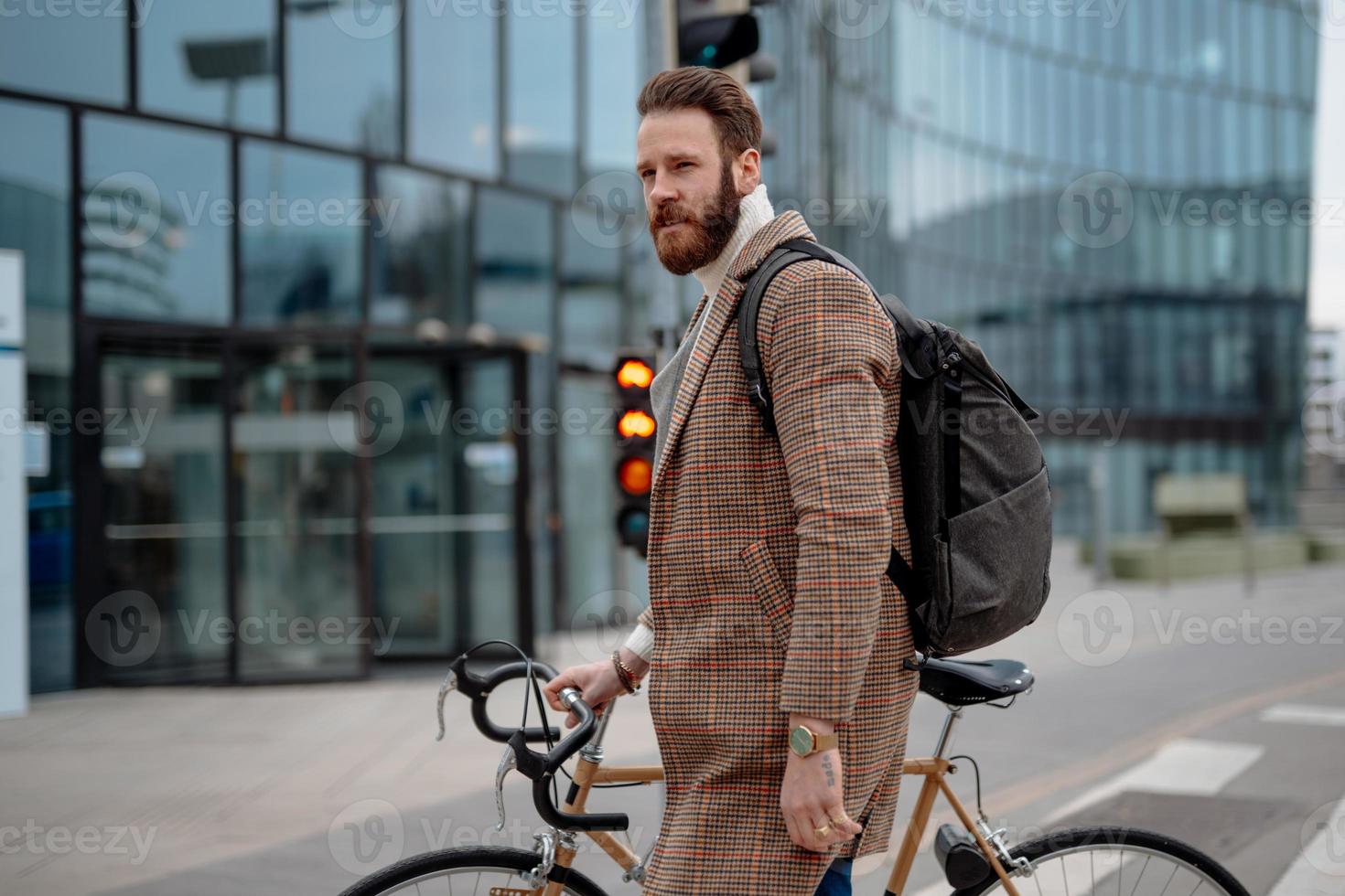 hombre de negocios con bicicleta camino al trabajo. ir al trabajo. gerente masculino en el centro de negocios. viajes ecológicos foto