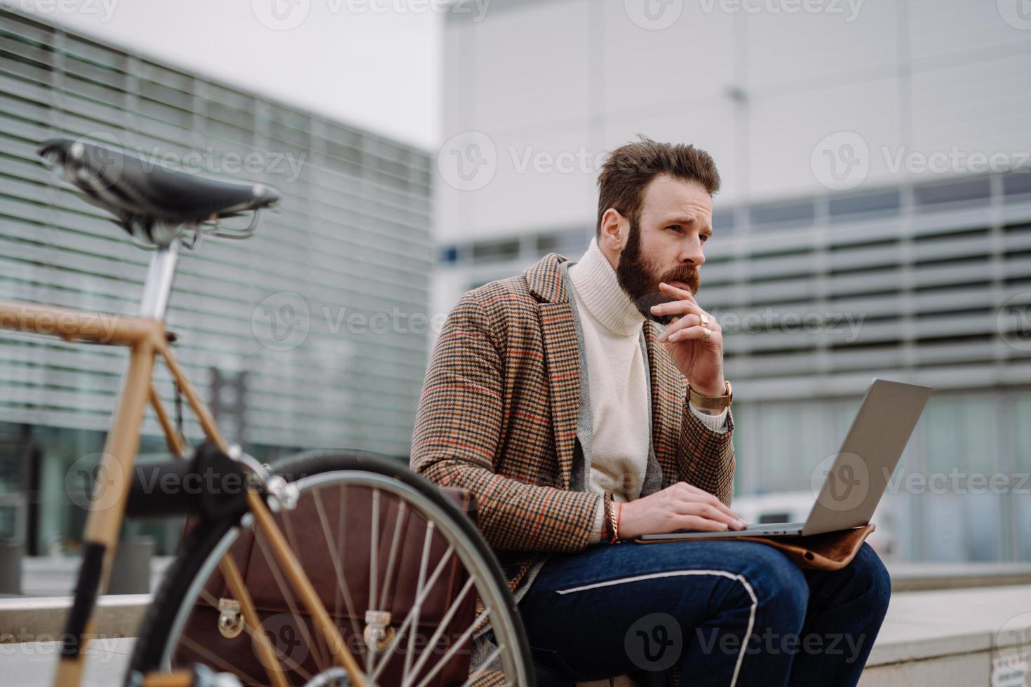 Contemplative businessman sitting outside and thinking about solving problem. Remote work photo