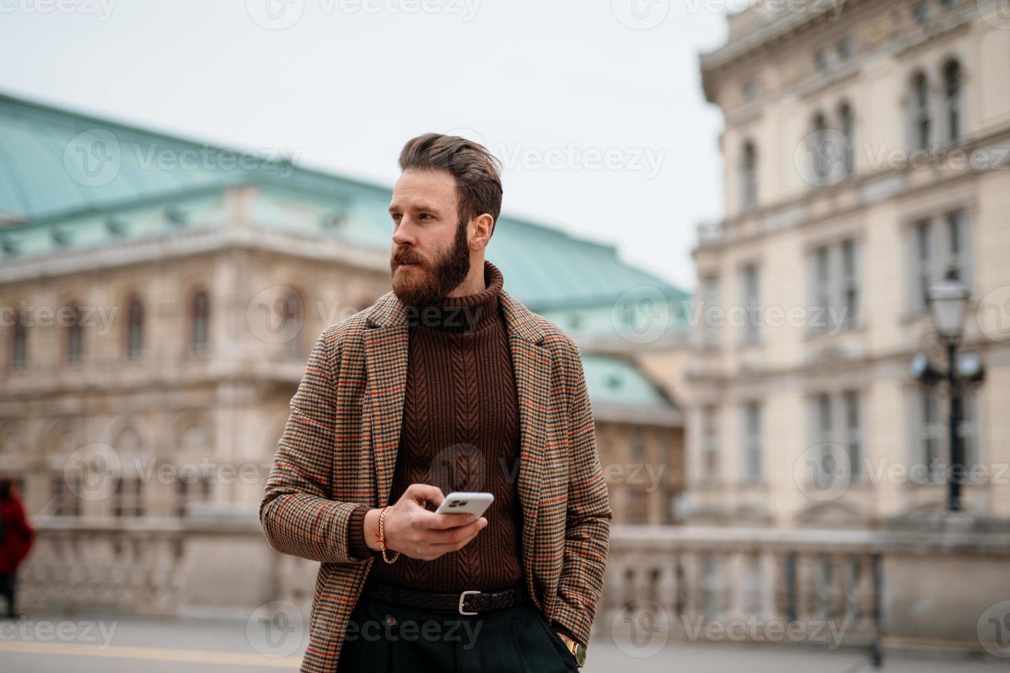 Young hipster businessman walking in city. Going to meeting. photo