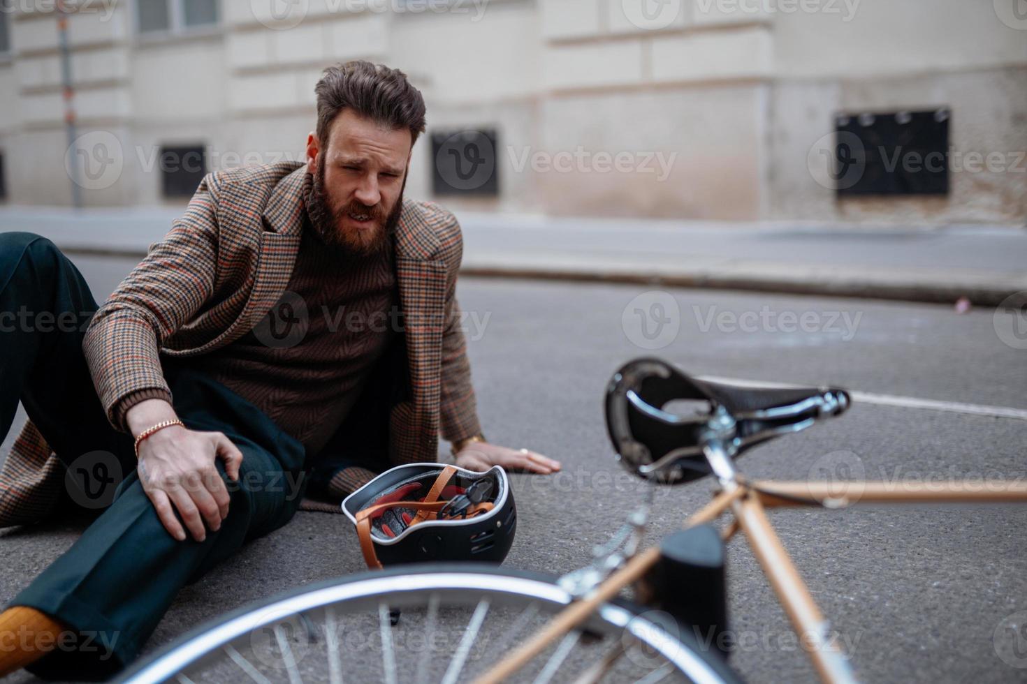 Bike accident in city. Man cyclist fall down. Bike injurie, injured knee photo