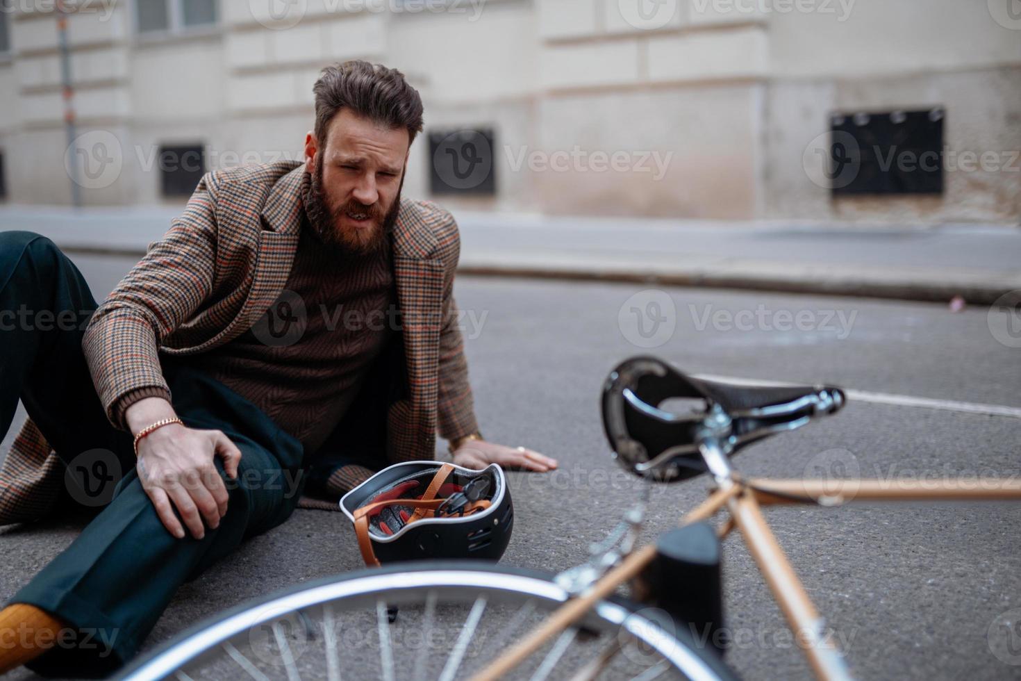 Bike accident in city. Man cyclist fall down. Bike injurie, injured knee photo