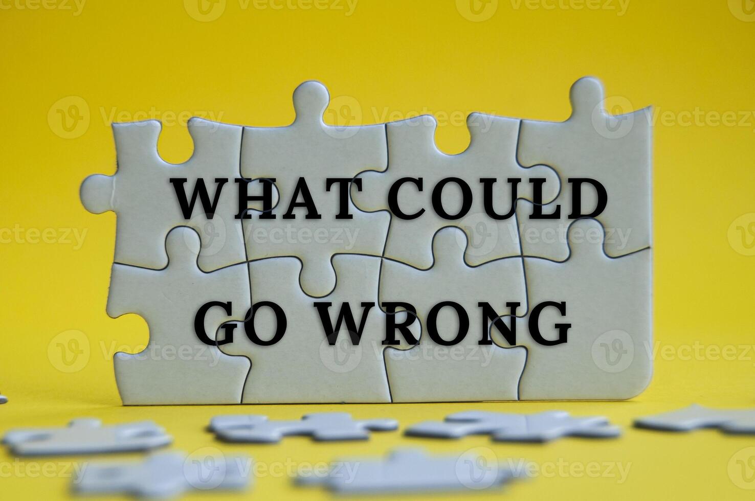 What could go wrong text on jigsaw puzzle on yellow cover background. photo