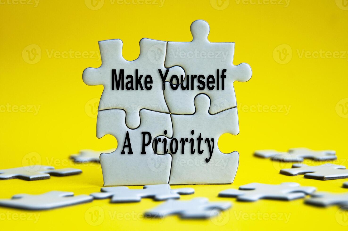 Make yourself a priority text on jigsaw puzzle with yellow background. photo