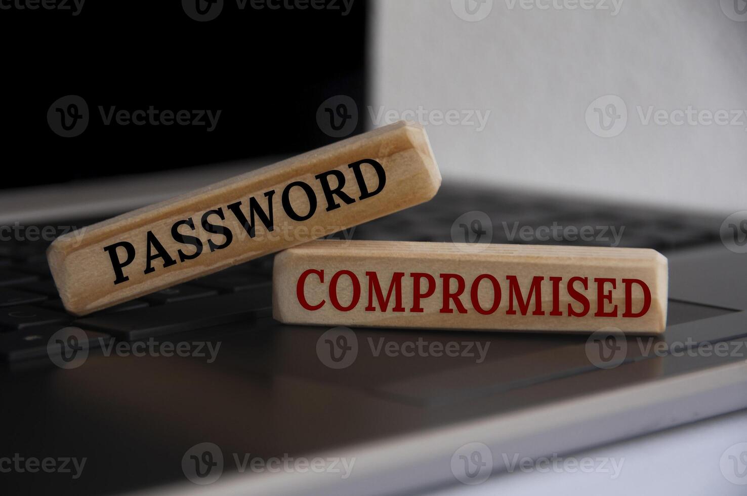 Password compromised text on wooden blocks on top of a laptop. 7189828