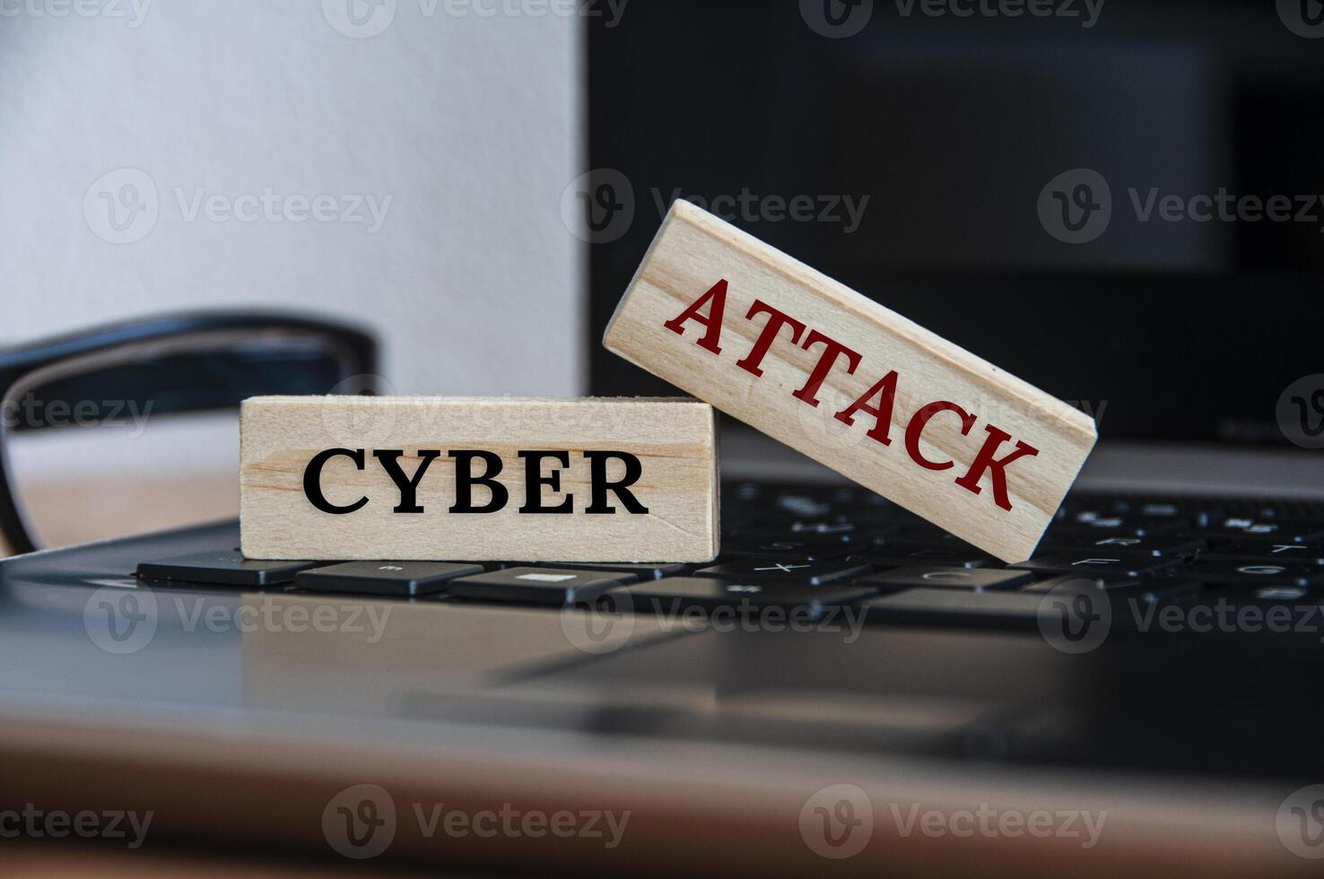 Cyber attack text on wooden blocks on top of a laptop. photo