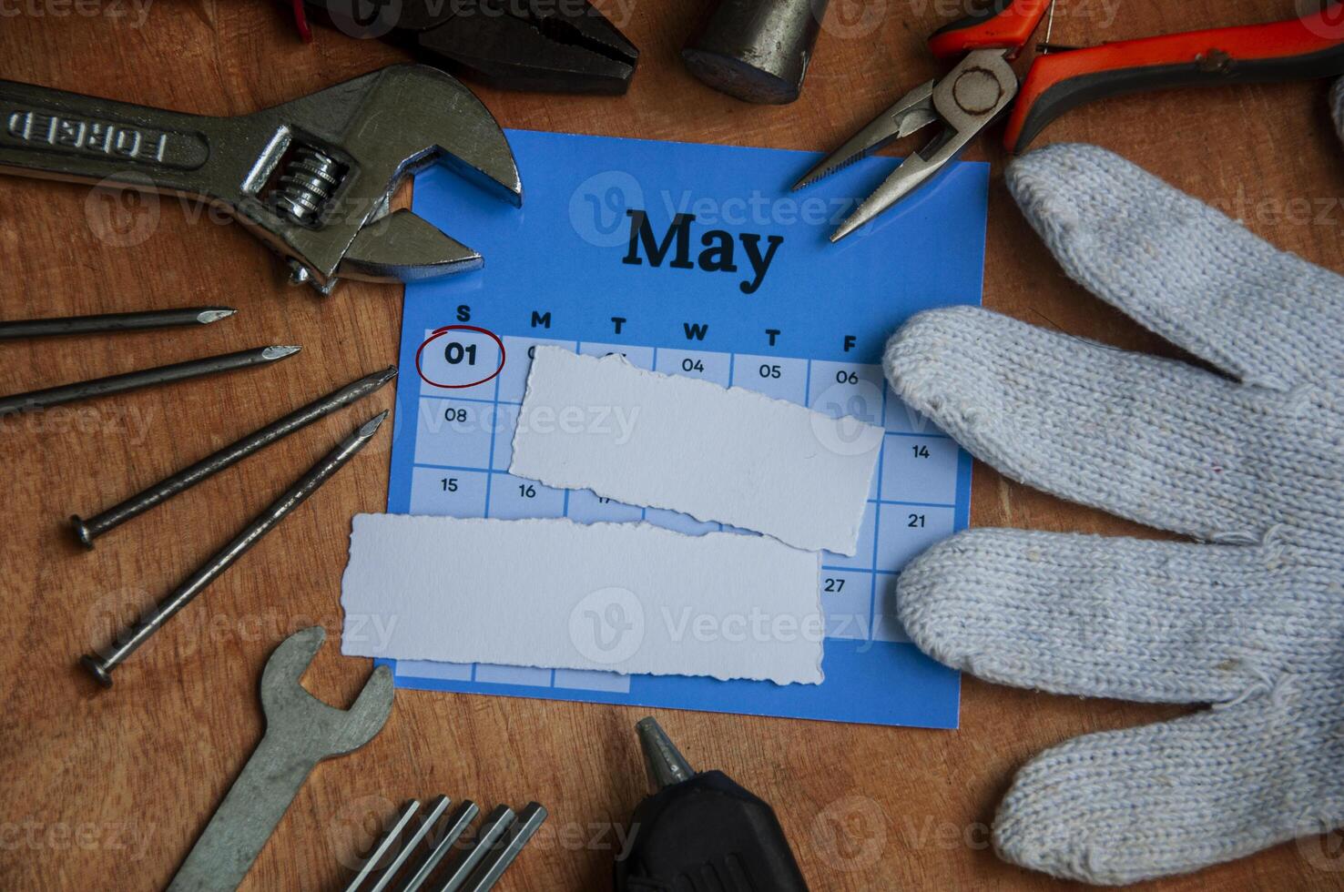 Top view of calendar and empty torn paper with working tools background. Labor day concept photo